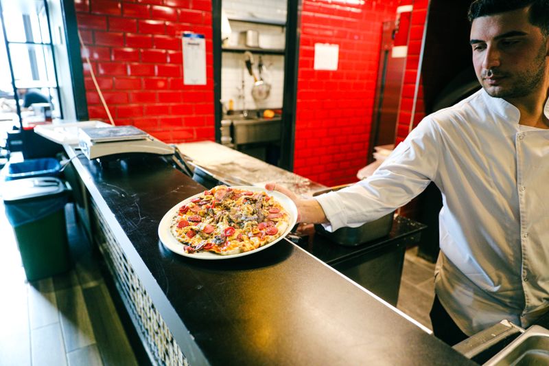 dion's pizza being freshly prepared in the Dions kitchen